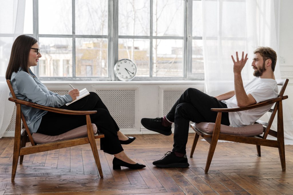 une femme et un homme discutant sur des fauteuils